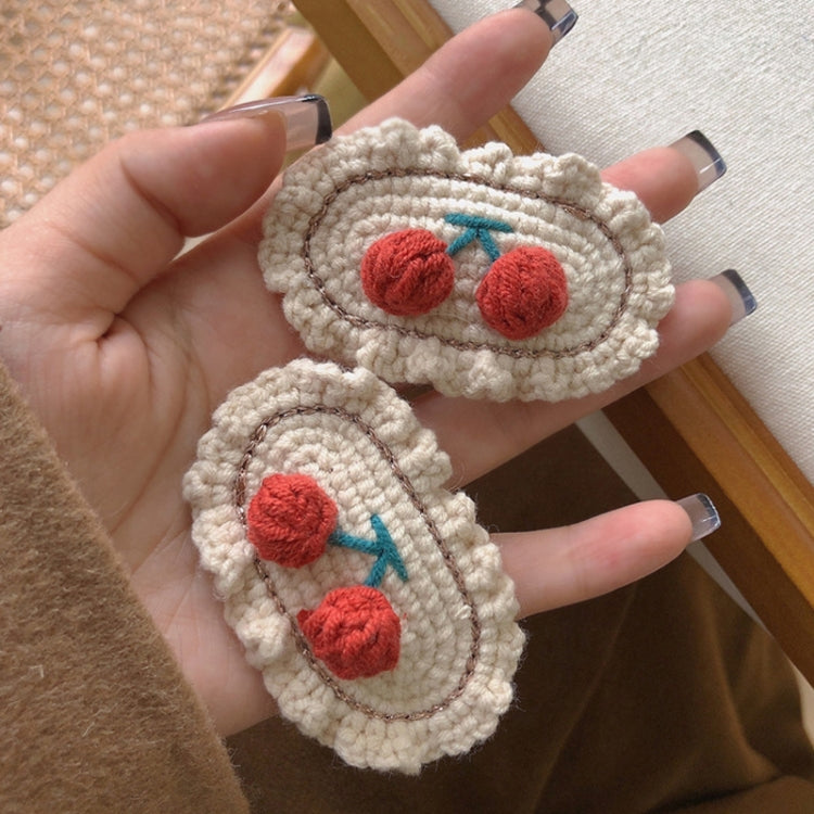 Pair of cream knit oval hair clips with red cherry and blue stem accents