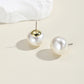 White pearl ball stud earrings with gold-tone metal posts and domed round fronts