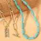 Turquoise cube-bead necklace and gold-tone link chains with rectangular charm and clasp