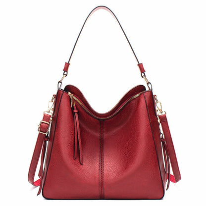 Red leather large tote bag with adjustable shoulder strap and zip pocket detail