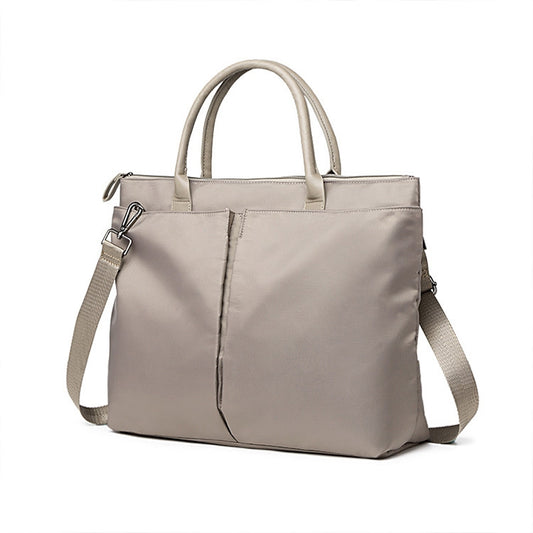 Light khaki laptop tote with top handles, shoulder strap, and front buckle pocket