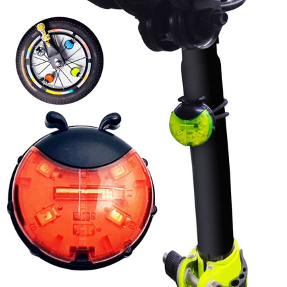 Orange ladybug-style wheel hub light on a black bicycle fork