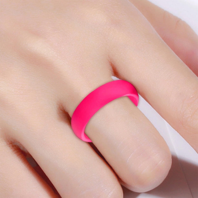 Wide pink silicone ring on finger, close-up