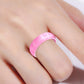 Pink glitter silicone ring, wide band, on finger close-up.