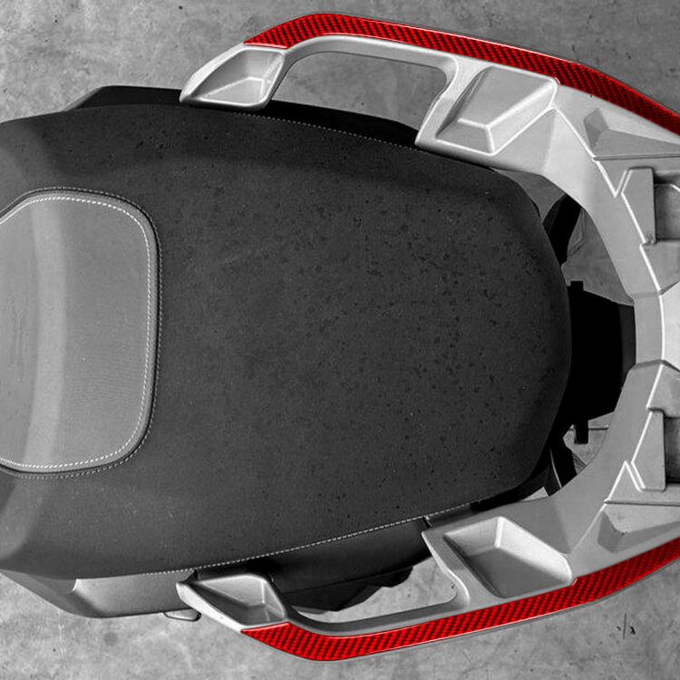 Close-up of red carbon-fiber rear handrail sticker around scooter seat edge