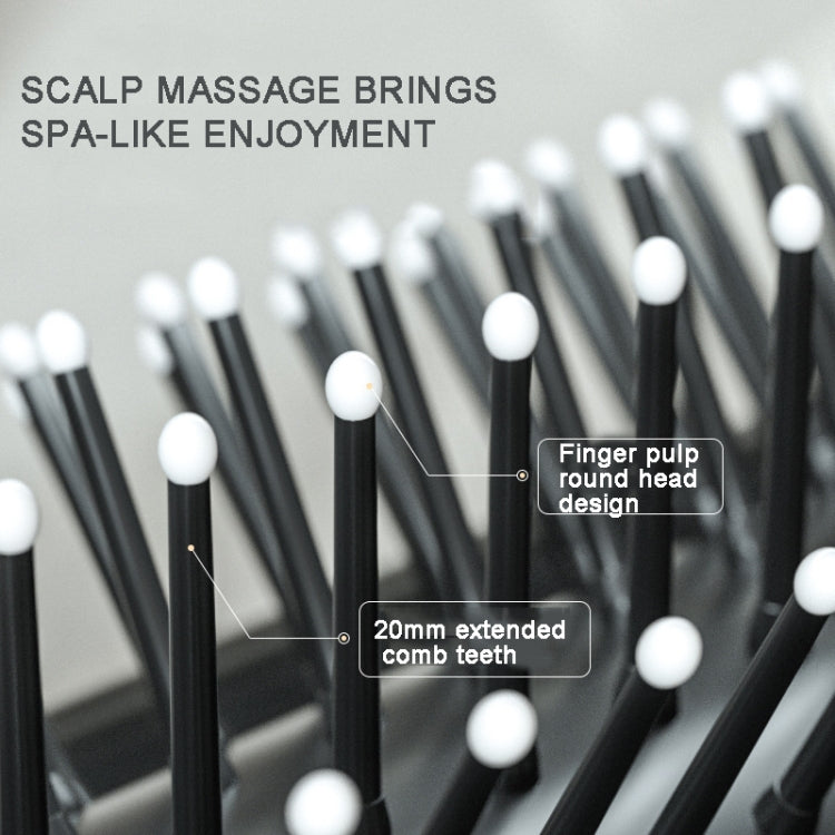 Close-up of black massage comb teeth on cushioned base with rounded tips