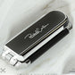 Integrated mirror panel on foldable hair comb with black grip and silver accents