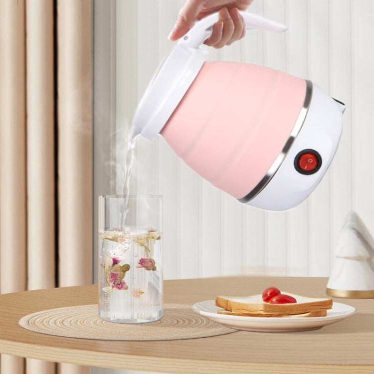 Pink folding silicone electric kettle pouring water, white handle and red power button