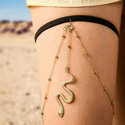 Gold layered thigh body chain with black band and dangling snake charm on thigh