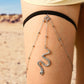 Silver layered thigh body chain with black band and dangling snake charm on thigh