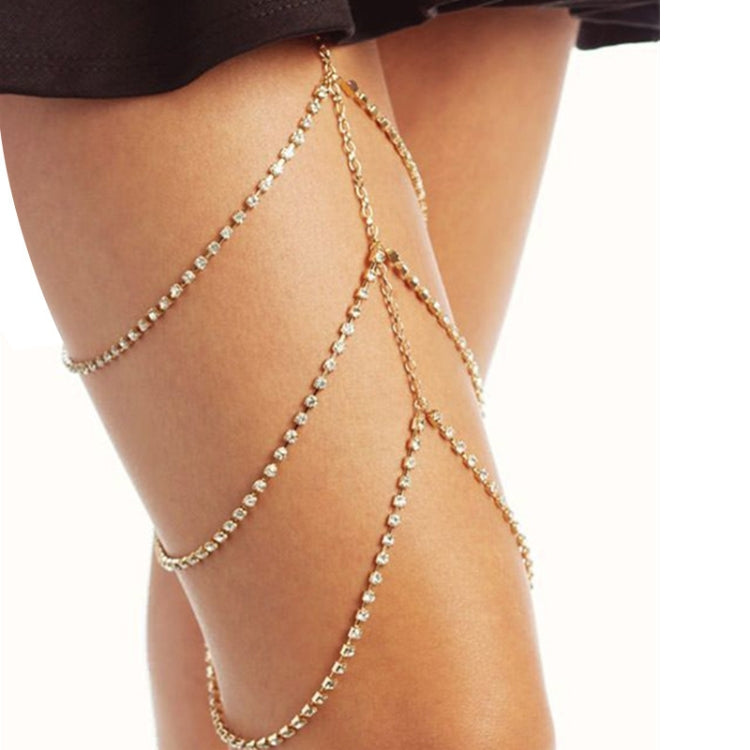 Gold thigh body chain with black band and long beaded chain draping on leg