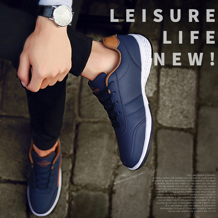 Navy leather sneakers on feet with lace-up design and white rubber sole