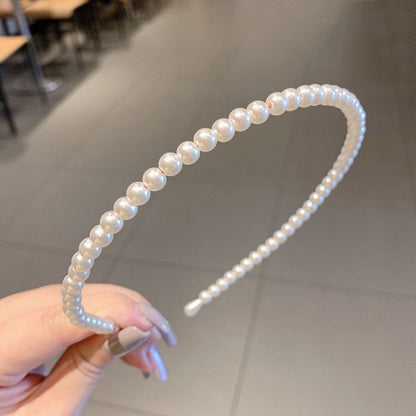 Pearl beaded headband with curved band and black inner comb, light iridescent finish