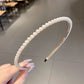 Pearl beaded headband with smooth curved band, black comb prongs visible