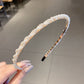 Pearl beaded headband with rounded curved band, black comb prongs at one end