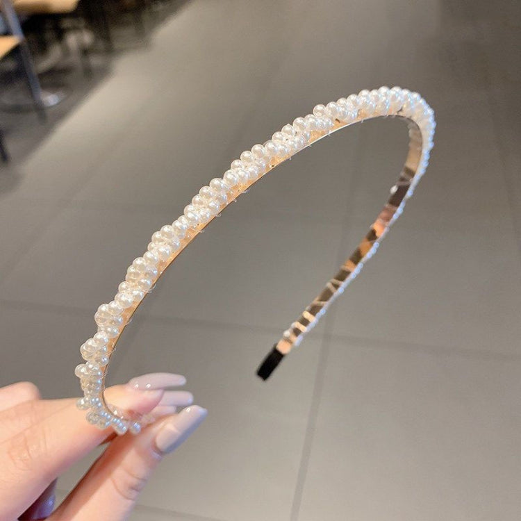 Pearl beaded headband with rounded curved band, black comb prongs at one end
