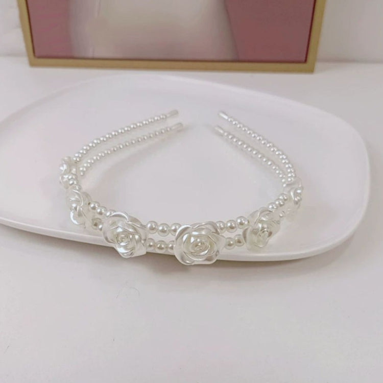 White pearl headband with layered pearl rows and centered rose appliques detail