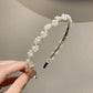 White pearl beaded headband with small clusters and black grip ends on the sides