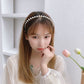 Pearl headband worn by a model with small round faux pearls across the top