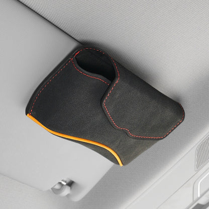 Car sun visor glasses case, black suede-look with red stitching and orange trim.