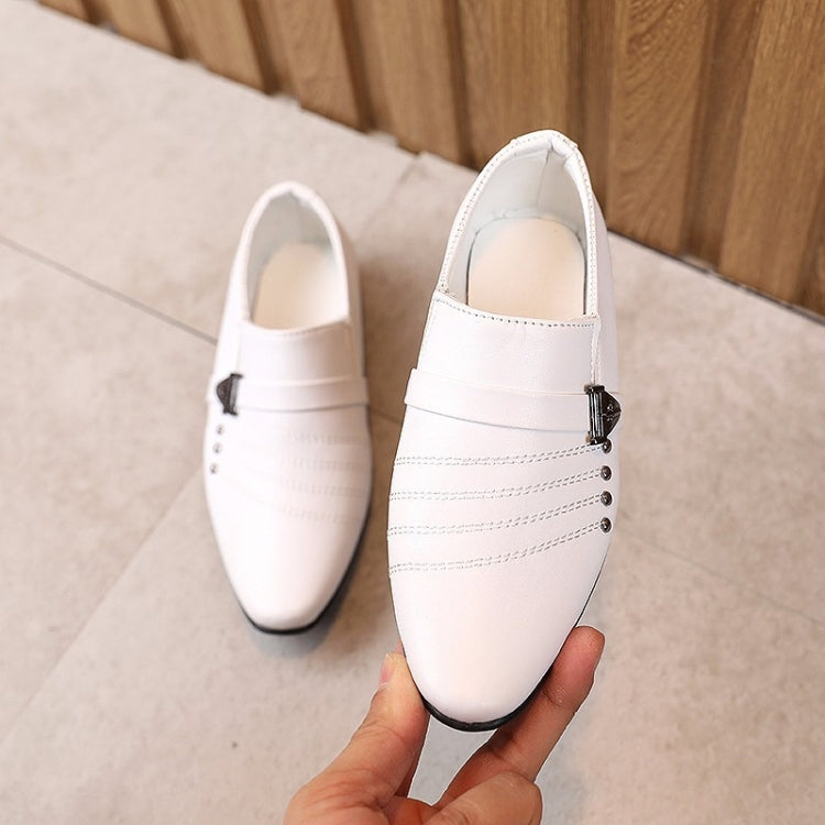 Kids white leather dress shoes with buckle strap and stitched panels, flat slip-on design