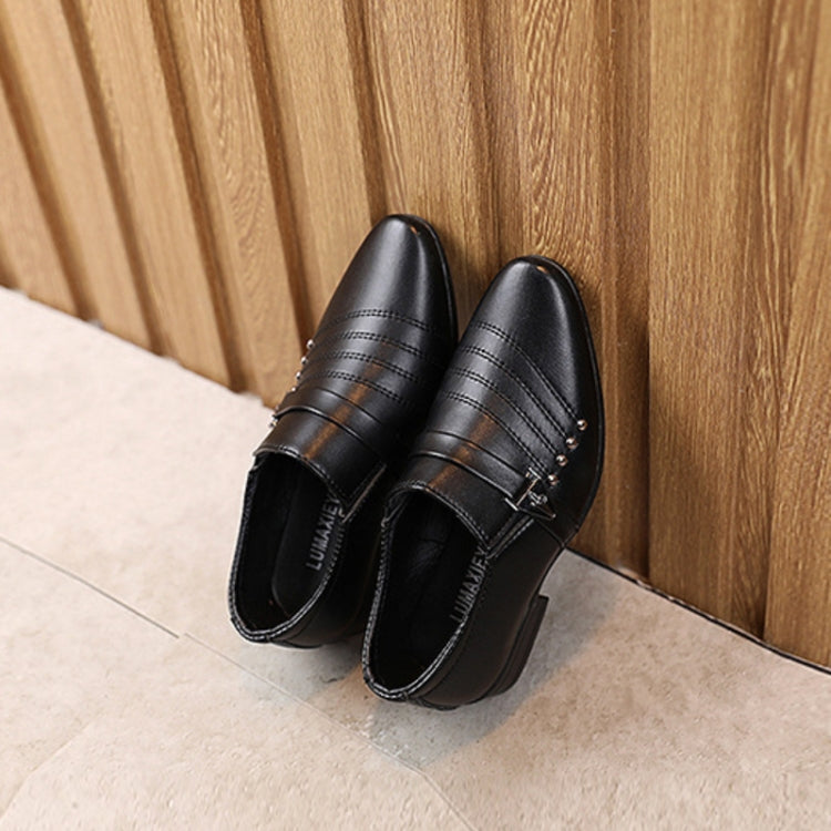 Black kids leather-look slip-on dress shoes with buckle strap and textured outsole