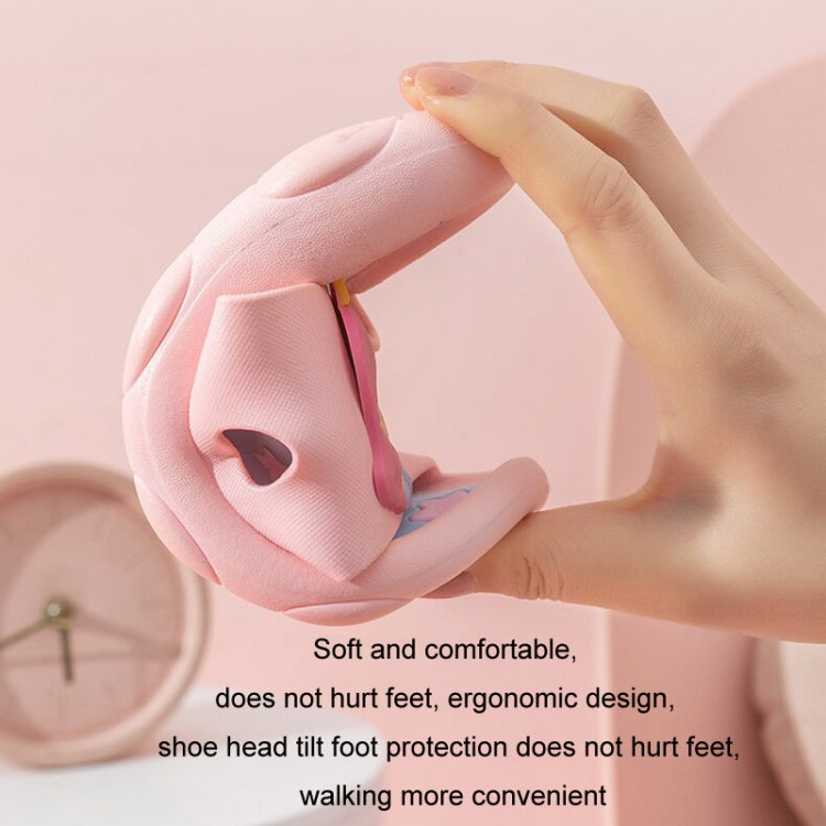 Pink soft-soled children’s slipper held open, showing padded lining and strap