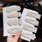 Assorted large pearl hair clips set with scalloped bead bars on packaging cards