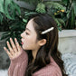 Pearl bead barrette hair clip securing side of dark hair near ponytail