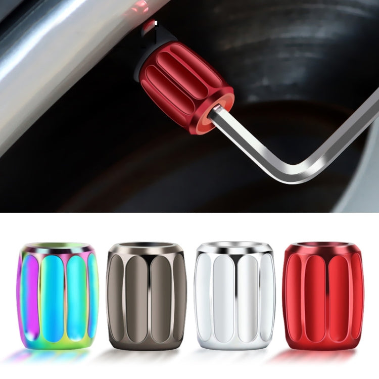 Colorful metal anti-theft tire valve caps on a valve stem, shown with key
