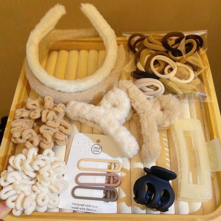 Assorted plush hair accessories tray with fuzzy headbands, scrunchies, and clips