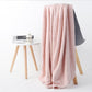 Light pink bath shower towel with waffle texture, draped over chair