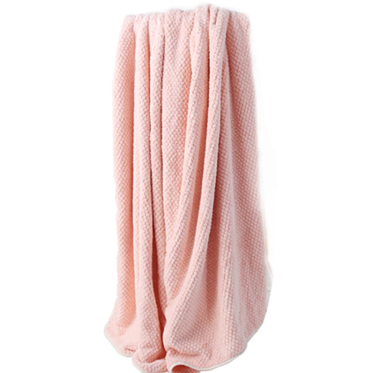 Light pink bath shower towel, neatly rolled with textured waffle weave