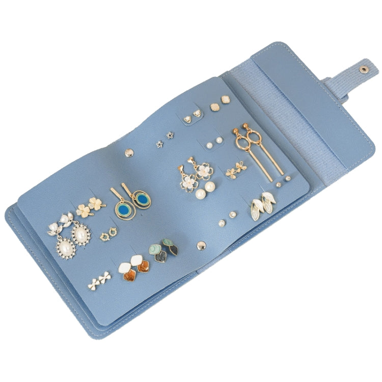 Blue book-shaped jewelry bag with multiple earring slots and compartments, travel-ready