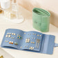 Book-shaped jewelry bag, blue, open with earrings displayed across inner pockets