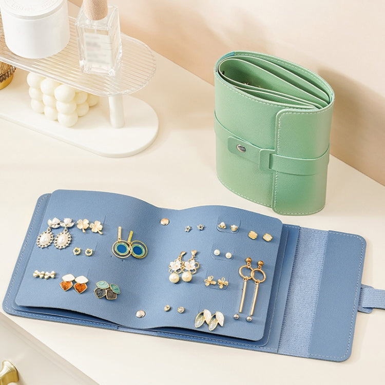 Book-shaped jewelry bag, blue, open with earrings displayed across inner pockets