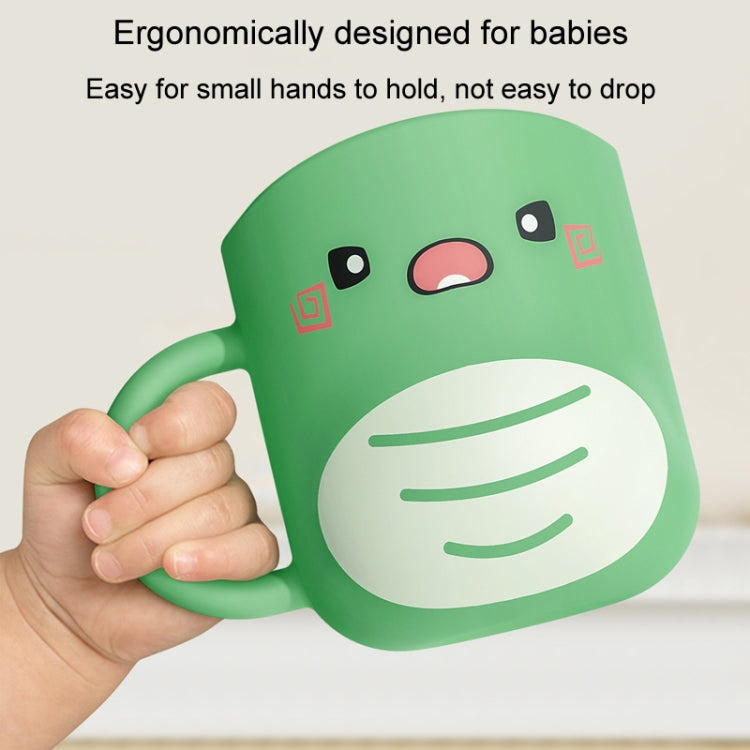 Green dinosaur baby cup held in a hand, with cartoon eyes and striped belly