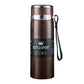 Brown vacuum insulated stainless steel mug with metal lid, front label, and wrist strap