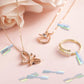 Gold-tone jewelry set with colorful hologram price tags and rings on pink background
