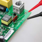 Red and black test probes touching a small circuit board