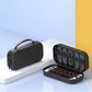 Black game console carrying case with mesh lid and handle, shown open with tray insert