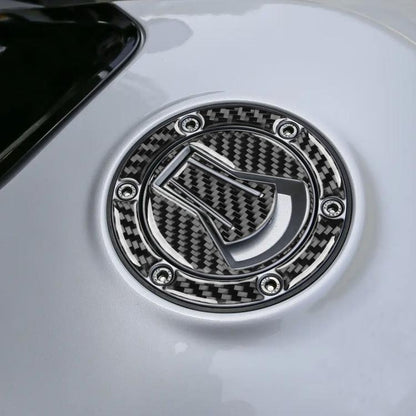 Black carbon-fiber fuel tank cap sticker with circular metal-style ring and bolt accents