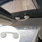 Two white suction cups connected by curved handle under car roof