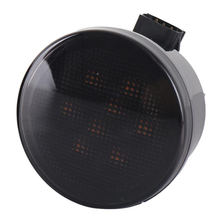 LED grille turn signal light close-up: amber dot pattern lens in black rim