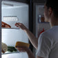 Small bottle organizer with circular slots inside refrigerator door storage
