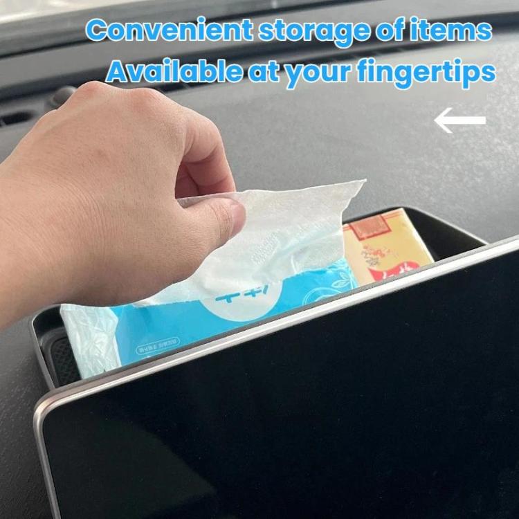Hand inserting items into black central storage tray box with open top