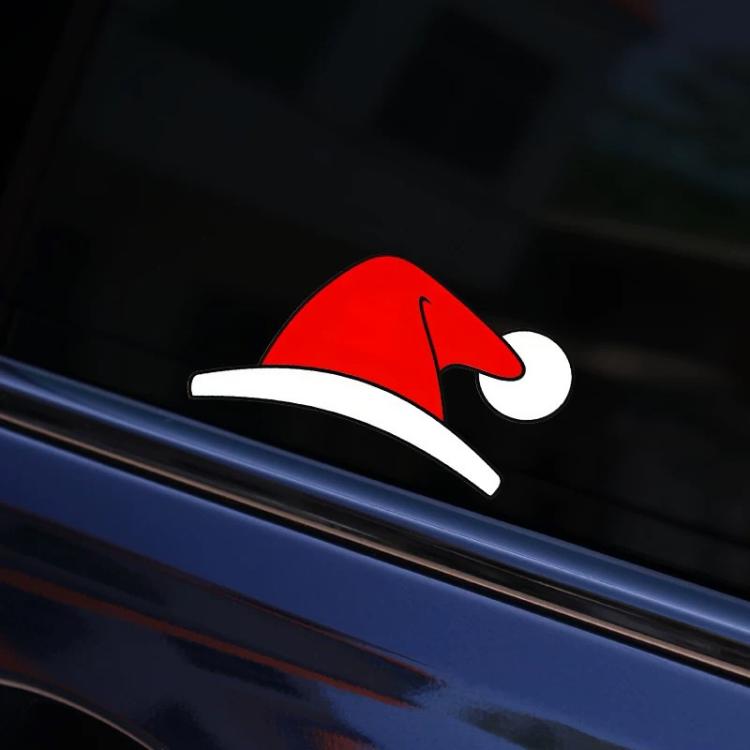 Close-up Santa hat Christmas window decal on dark car glass, red with white brim