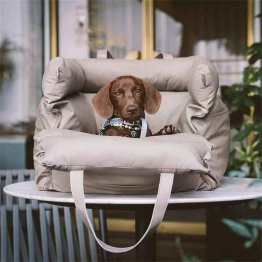 Light gray pet car seat bed with thick bolsters and shoulder straps, resting dog