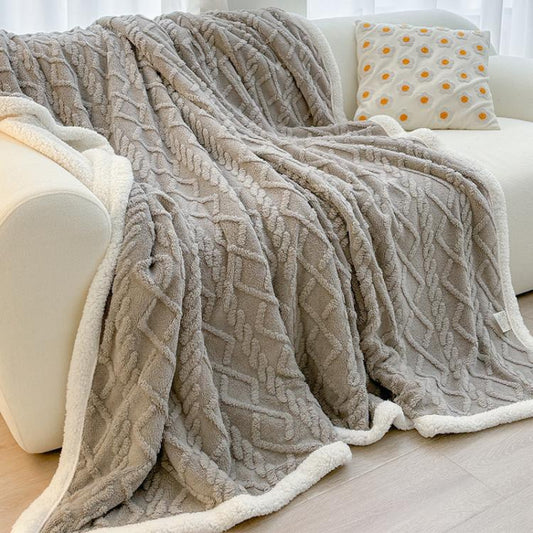 Beige thick fleece throw blanket with raised cable-like texture and fluffy sherpa border