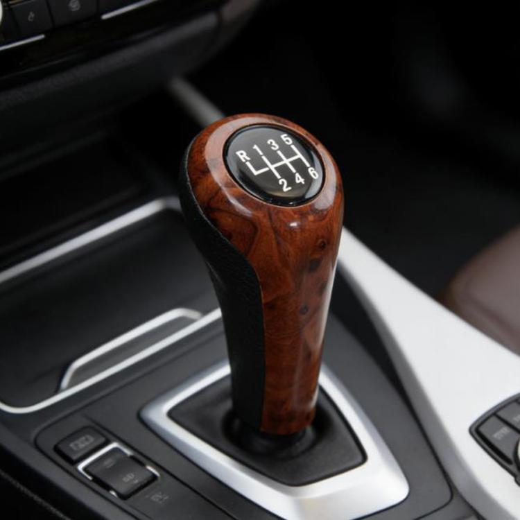 Dark brown wood-grain 6-speed gear shift knob installed in car console with black trim